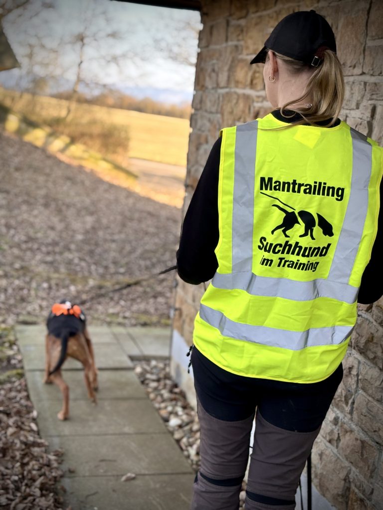 Mantrailing-Training mit Hund und Mensch an einer Hauswand
